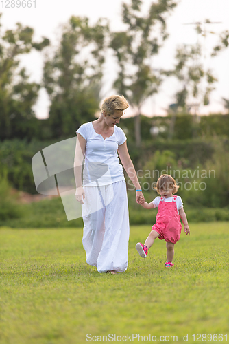 Image of mother and little daughter playing at backyard