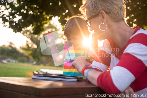 Image of mom and her little daughter using tablet computer