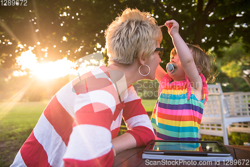 Image of mom and her little daughter using tablet computer