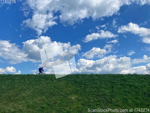 Image of An unidentified man ride mountain bike on a country road 