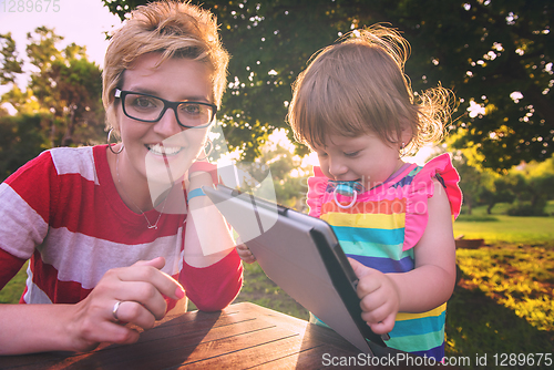 Image of mom and her little daughter using tablet computer
