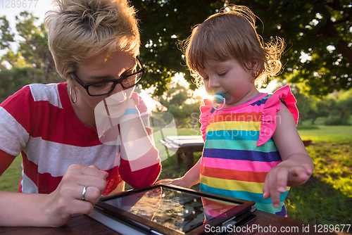 Image of mom and her little daughter using tablet computer