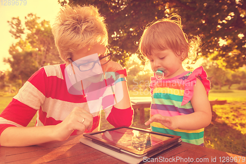 Image of mom and her little daughter using tablet computer