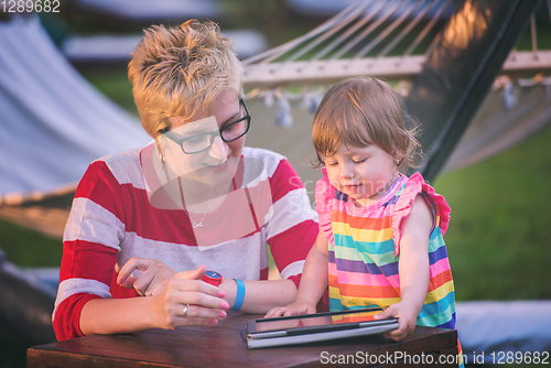 Image of mom and her little daughter using tablet computer