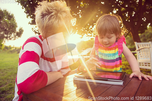 Image of mom and her little daughter using tablet computer