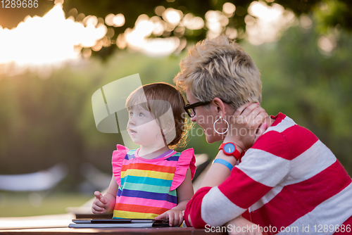 Image of mom and her little daughter using tablet computer