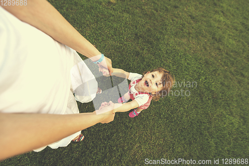 Image of mother and little daughter playing at backyard