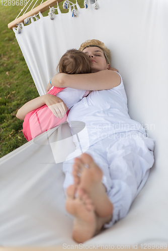 Image of mother and a little daughter relaxing in a hammock