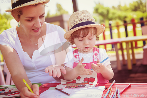 Image of mom and little daughter drawing a colorful pictures