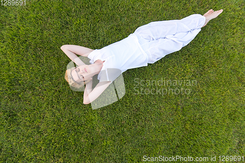 Image of top view of young woman relaxing on the grass