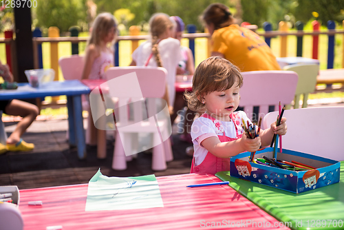 Image of little girl drawing a colorful pictures