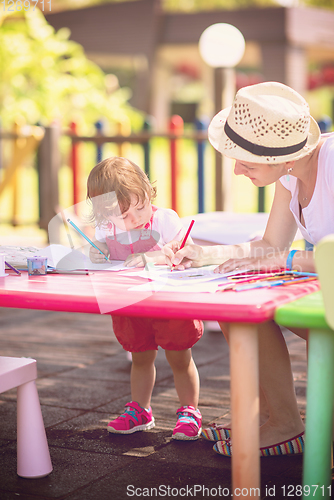 Image of mom and little daughter drawing a colorful pictures