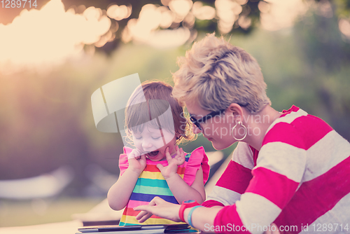 Image of mom and her little daughter using tablet computer