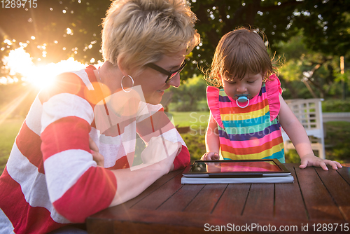 Image of mom and her little daughter using tablet computer