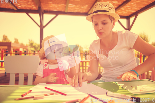 Image of mom and little daughter drawing a colorful pictures