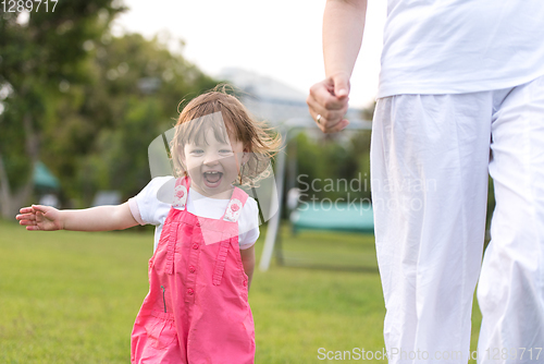 Image of mother and little daughter playing at backyard