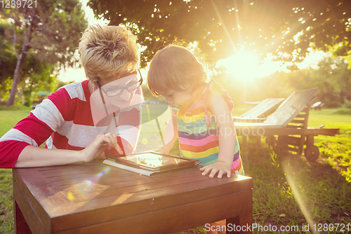 Image of mom and her little daughter using tablet computer