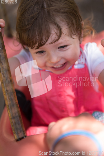 Image of little girl swinging  on a playground