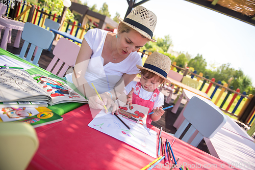 Image of mom and little daughter drawing a colorful pictures