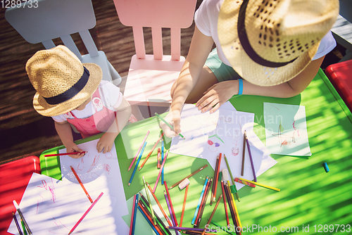 Image of mom and little daughter drawing a colorful pictures