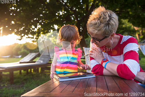 Image of mom and her little daughter using tablet computer