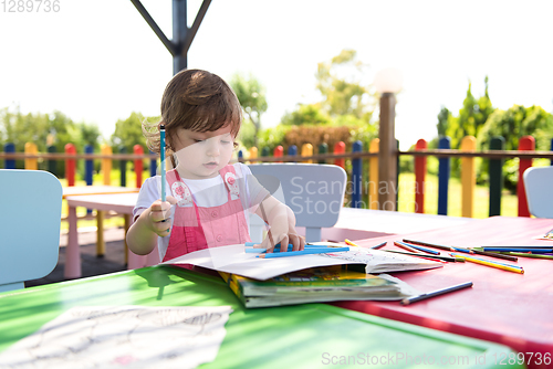 Image of little girl drawing a colorful pictures