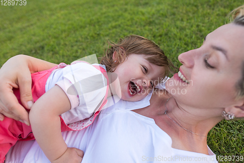 Image of mother and little daughter playing at backyard