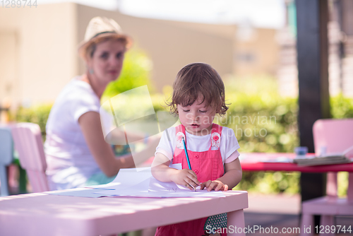 Image of mom and little daughter drawing a colorful pictures