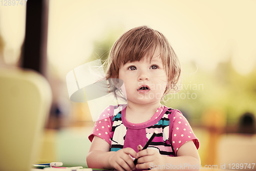 Image of little girl drawing a colorful pictures