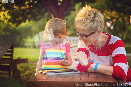 Image of mom and her little daughter using tablet computer