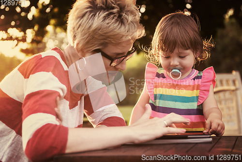 Image of mom and her little daughter using tablet computer