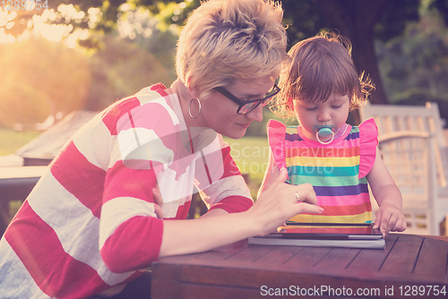 Image of mom and her little daughter using tablet computer