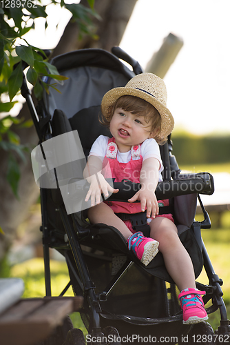 Image of baby girl sitting in the baby stroller