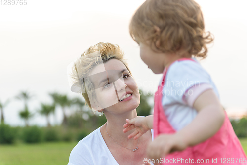 Image of mother and little daughter playing at backyard