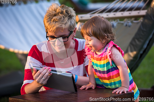 Image of mom and her little daughter using tablet computer