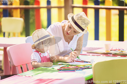 Image of mom and little daughter drawing a colorful pictures