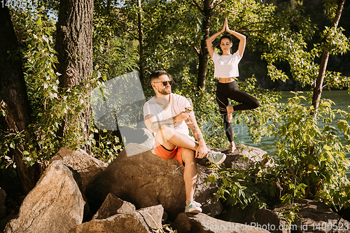 Image of Young couple having fun and spending time at riverside in sunny day