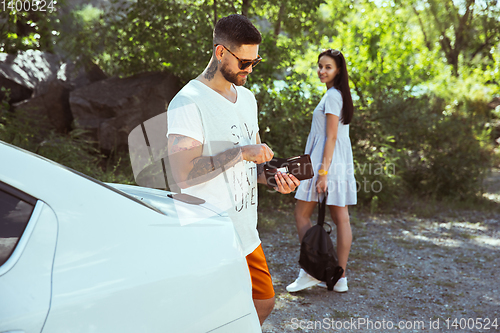 Image of Young couple preparing for vacation in sunny day