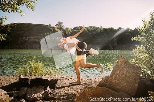 Image of Young couple having fun and spending time at riverside in sunny day