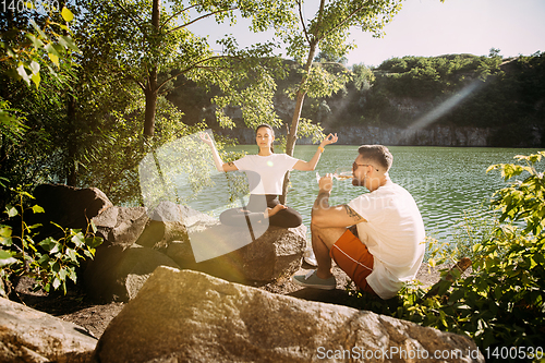 Image of Young couple having fun and spending time at riverside in sunny day