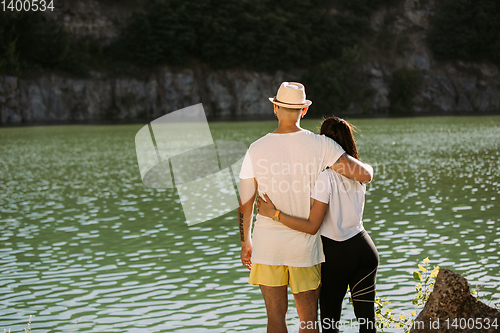 Image of Young couple having fun and spending time at riverside in sunny day