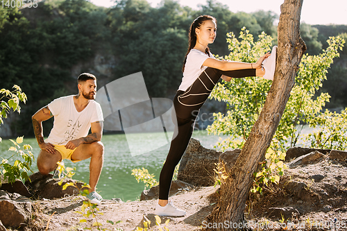 Image of Young couple having fun and spending time at riverside in sunny day