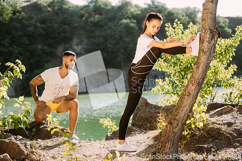 Image of Young couple having fun and spending time at riverside in sunny day