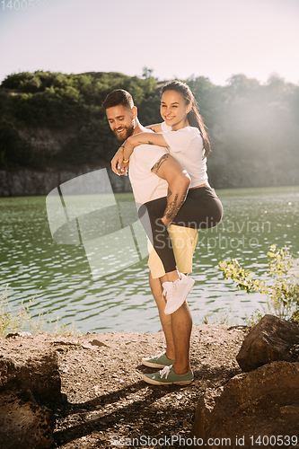 Image of Young couple having fun and spending time at riverside in sunny day