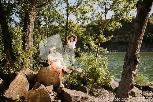 Image of Young couple having fun and spending time at riverside in sunny day