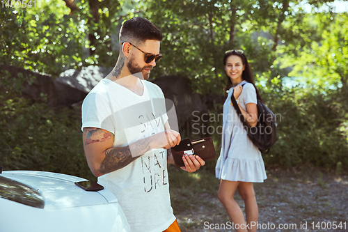 Image of Young couple preparing for vacation in sunny day