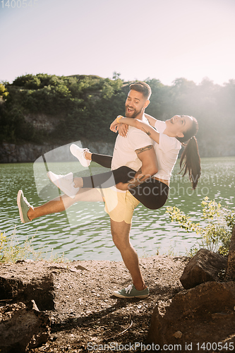 Image of Young couple having fun and spending time at riverside in sunny day