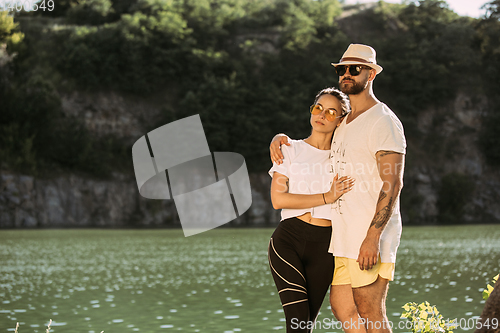 Image of Young couple having fun and spending time at riverside in sunny day