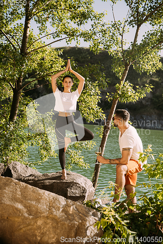 Image of Young couple having fun and spending time at riverside in sunny day