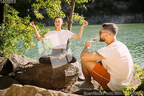 Image of Young couple having fun and spending time at riverside in sunny day